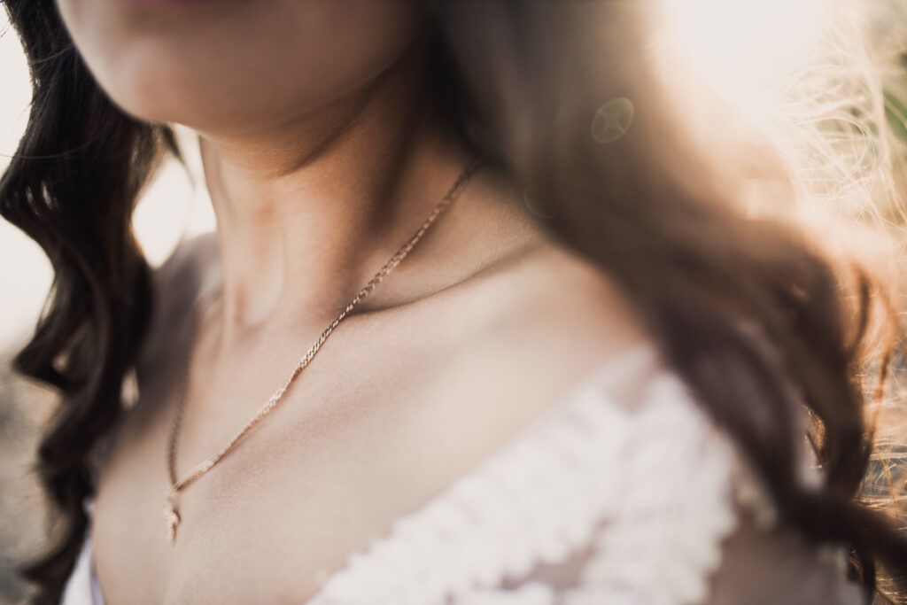 Curly-haired bride in a wedding dress in rays of the sun.