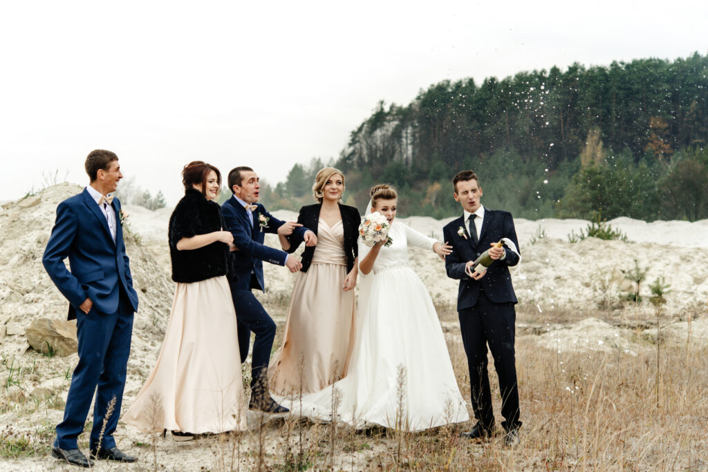 bride and groom with happy groomsmen and bridesmaids having fun and laughing and popping champagne