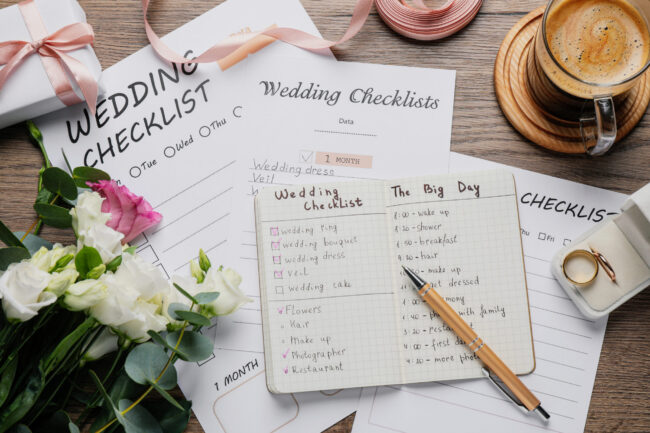 Flat lay composition with Wedding Checklists on wooden table Flat lay composition with Wedding Checklists on wooden table